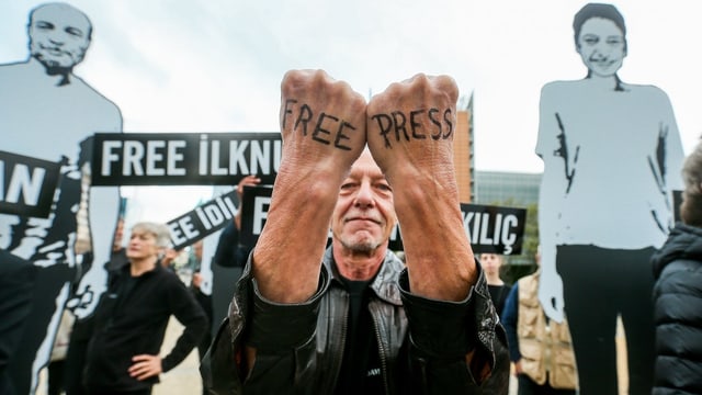 Mann hat auf seine zwei Handrücken «Free Press» geschrieben. Mann hat auf seine zwei Handrücken «Free Press» geschrieben.