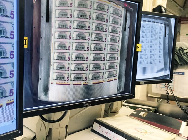 Drei Monitore: darauf zu sehen sind Dollarnoten. Drei Monitore: darauf zu sehen sind Dollarnoten.