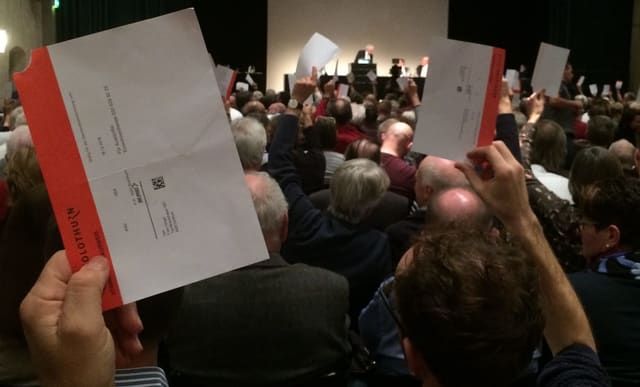 Menschen halten Stimmkarten in die Höhe an der Gemeindeversammlung in Solothurn Menschen halten Stimmkarten in die Höhe an der Gemeindeversammlung in Solothurn