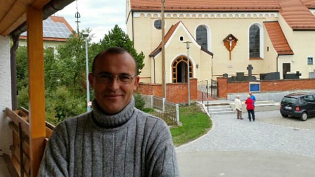 Hassan Hammed lächelnd vor einer Kirche. Hassan Hammed lächelnd vor einer Kirche.