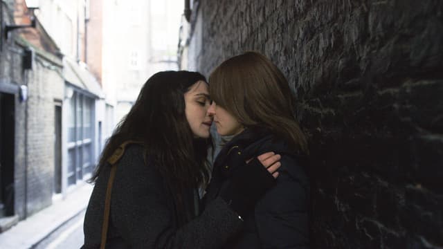 Zwei Frauen küssen sich, sind an eine Mauer angelehnt. Zwei Frauen küssen sich, sind an eine Mauer angelehnt.