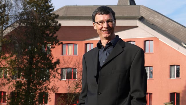 Jürg Bregenzer vor einem Haus. Jürg Bregenzer vor einem Haus.