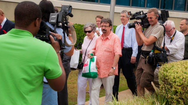 Kameraleute begleiten die ältere Dame und ihren Sohn auf dem Weg zum Lotterie-Büro. Kameraleute begleiten die ältere Dame und ihren Sohn auf dem Weg zum Lotterie-Büro.