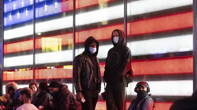 Amerikanerinnen und Amerikaner verfolgen die Wahlnacht am Times Square in New York City. Amerikanerinnen und Amerikaner verfolgen die Wahlnacht am Times Square in New York City.