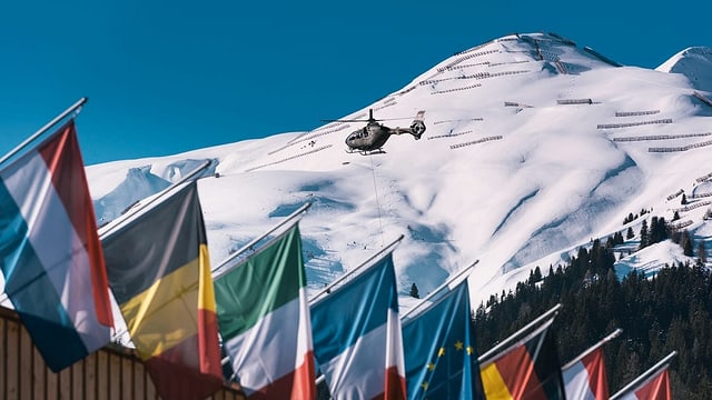 Hubschrauber über dem Davoser Kongresszentrum mit Landesfahnen Hubschrauber über dem Davoser Kongresszentrum mit Landesfahnen