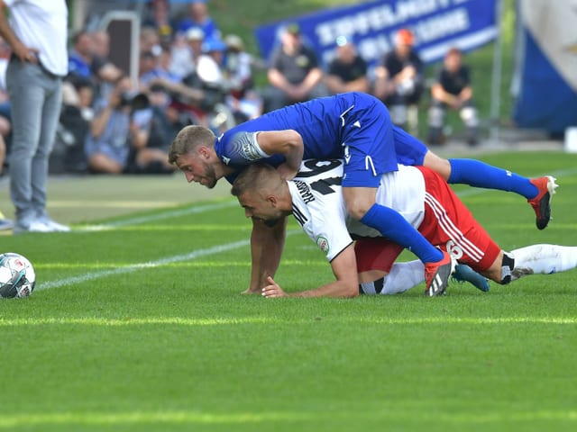 Der Karlsruher Marc Lorenz im Zweikampf mit Lukas Hinterseer vom HSV.