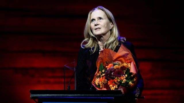 Eine Frau hält einen Blumenstrauss. Eine Frau hält einen Blumenstrauss.