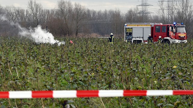 Eine Rauchfahen steigt aus einem Feld auf. In der Nähe steht ein Löschfahrzeug der Feuerwehr. Eine Rauchfahen steigt aus einem Feld auf. In der Nähe steht ein Löschfahrzeug der Feuerwehr.