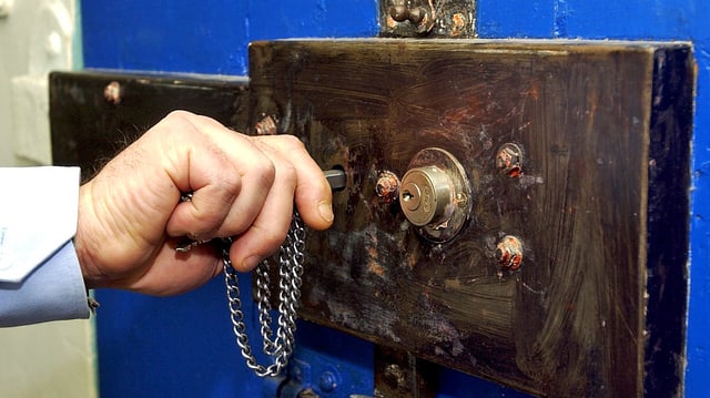 Mann öffnet Gefängniszelle Mann öffnet Gefängniszelle