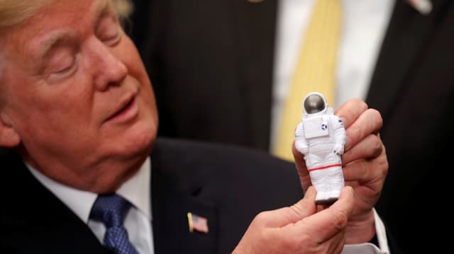 Donald Trump mit einer Astronauten-Figur. Donald Trump mit einer Astronauten-Figur.