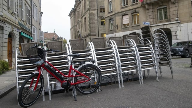 Ein Fahrrad steht vor einem Stapel Stühle auf der Strasse. Ein Fahrrad steht vor einem Stapel Stühle auf der Strasse.