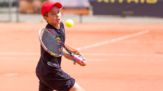 Knabe am Tennisspielen Knabe am Tennisspielen