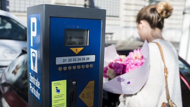 Eine Frau neben einer Parkuhr Eine Frau neben einer Parkuhr