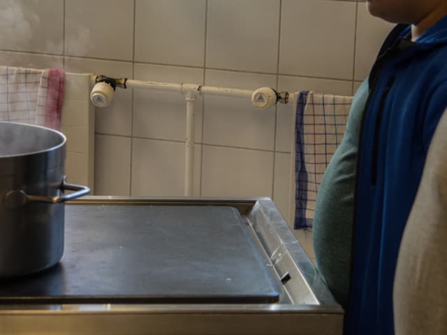 Zwei übergewichtige Jungen schauen auf einen Kochtopf. Zwei übergewichtige Jungen schauen auf einen Kochtopf.