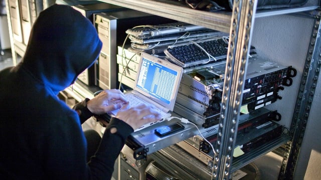Symbolbild, ein Hacker sitzt an einem Computer und programmiert Codes. Symbolbild, ein Hacker sitzt an einem Computer und programmiert Codes.