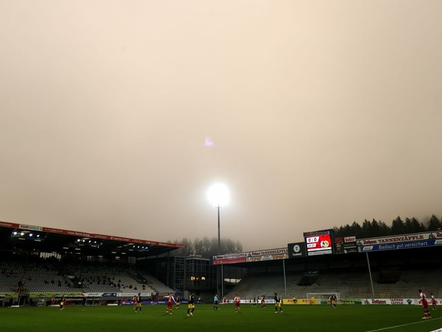Oranger Himmel über einem Fussballstadion.