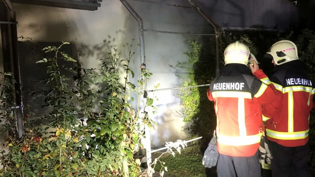 Feuerwehrleute stehen vor Qualm Feuerwehrleute stehen vor Qualm