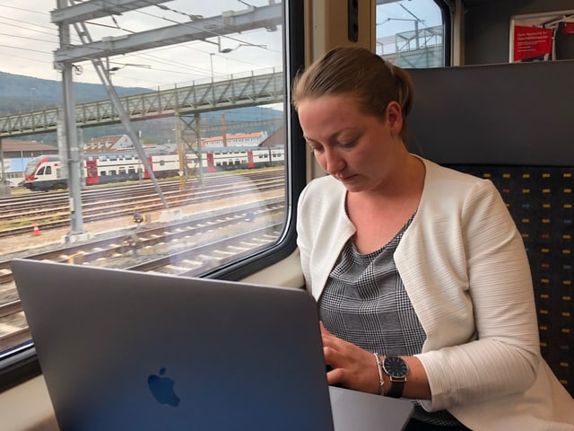 Liz ist mit ihrem Laptop im Zug.