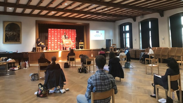 Saal mit Personen aus Stühlen mit Abstand Saal mit Personen aus Stühlen mit Abstand