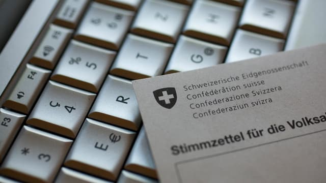 Auf einer Computertastatur liegt ein Stimmzettel für die Volksabstimmung Auf einer Computertastatur liegt ein Stimmzettel für die Volksabstimmung
