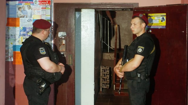 Polizisten vor Hauseingang Polizisten vor Hauseingang