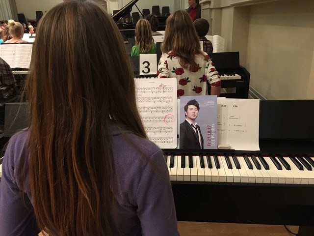 Mächden mit braunen Haaren und violettem Pulli am Klavier Mächden mit braunen Haaren und violettem Pulli am Klavier