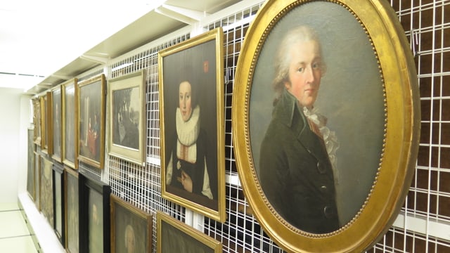 Reihe von alten Portraitgemälden an einer Gitterwand. Reihe von alten Portraitgemälden an einer Gitterwand.