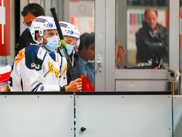Eishockey-Spieler auf der Strafbank mit Maske Eishockey-Spieler auf der Strafbank mit Maske