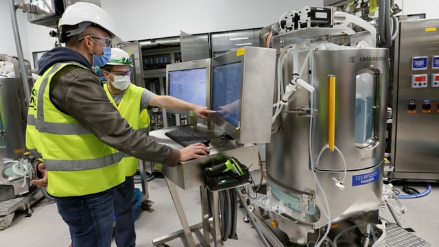 Zwei Techniker mit Laborutensilien. Zwei Techniker mit Laborutensilien.