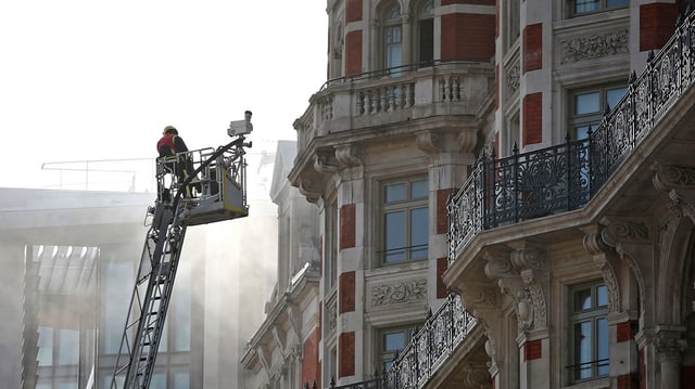 Feuerwehrmann auf Feuerleiter vor dem Hotel Feuerwehrmann auf Feuerleiter vor dem Hotel