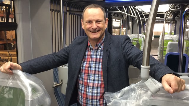 Ein Mann steht im Innern eines Buses, der bald ausgeliefert wird. Ein Mann steht im Innern eines Buses, der bald ausgeliefert wird.