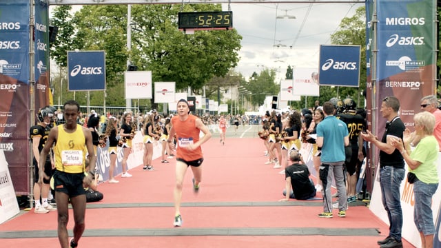 Zwei Marathonläufer überqueren die Ziellinie des Laufs. Zwei Marathonläufer überqueren die Ziellinie des Laufs.