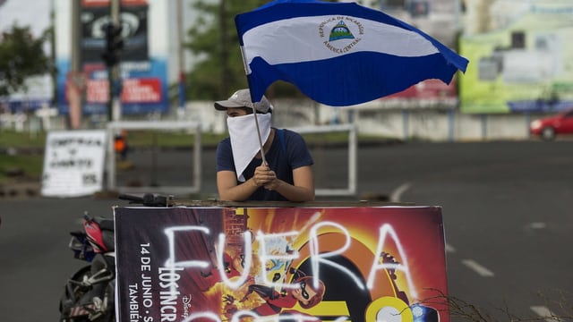 Ein Demonstrant mit einer Flagge Nicaraguas Ein Demonstrant mit einer Flagge Nicaraguas