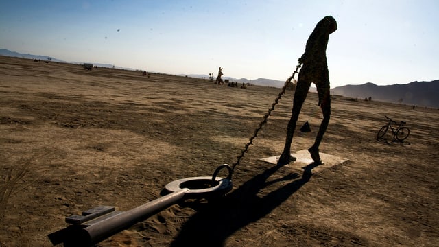Foto der Installation «Key Note» von Michael Christian: Die Skulputur zeigt einen Menschen, der einen Riesenschlüssel hinter sich herzieht. Foto der Installation «Key Note» von Michael Christian: Die Skulputur zeigt einen Menschen, der einen Riesenschlüssel hinter sich herzieht.