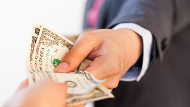 Zu sehen sind Hände, die Geld austauschen. Zu sehen sind Hände, die Geld austauschen.
