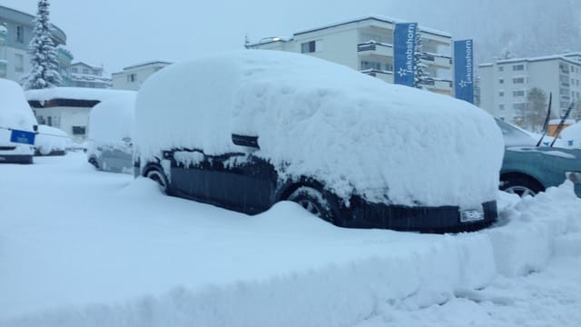 Ein Auto ist stark eingeschneit.