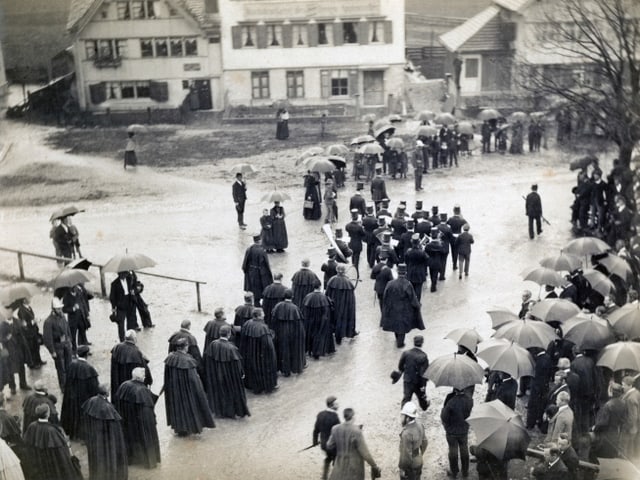 Schwarzweissfoto mit Menschen in einem Umzug, die Regenschirme sind offen. Schwarzweissfoto mit Menschen in einem Umzug, die Regenschirme sind offen.