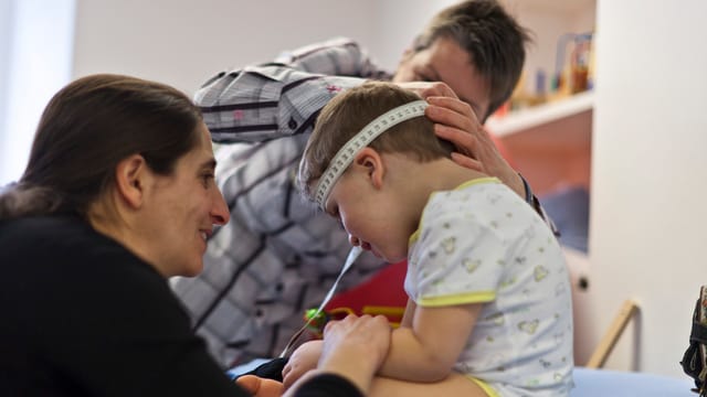 Zwei Frauen kümmern sich um ein Kleinkind. Zwei Frauen kümmern sich um ein Kleinkind.