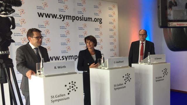 Beni Würth, Doris Leuthard, Bruno Damann am Symposium an Rednerpulten Beni Würth, Doris Leuthard, Bruno Damann am Symposium an Rednerpulten