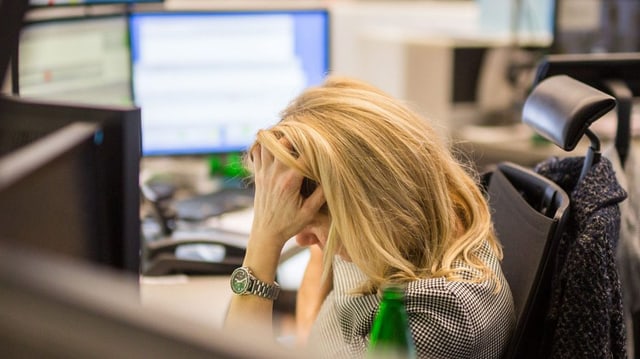 Börsenhändlerin vor Bildschirmen stützt ihren Kopf. Börsenhändlerin vor Bildschirmen stützt ihren Kopf.