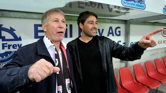 Schmid hebt seinen rechten Arm vorsichtig und will zum Jubeln ansetzen, er trägt einen FC-Aarau-Schal um den Hals. Schmid hebt seinen rechten Arm vorsichtig und will zum Jubeln ansetzen, er trägt einen FC-Aarau-Schal um den Hals.