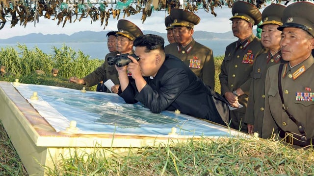 Kim Jong-un verfolgt eine Militärübung mit dem Fernglas. Kim Jong-un verfolgt eine Militärübung mit dem Fernglas.
