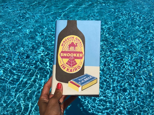 Annette König hält das Buch von Waguih Ghali: «Snooker in Kairo» vor blaues Wasser Annette König hält das Buch von Waguih Ghali: «Snooker in Kairo» vor blaues Wasser