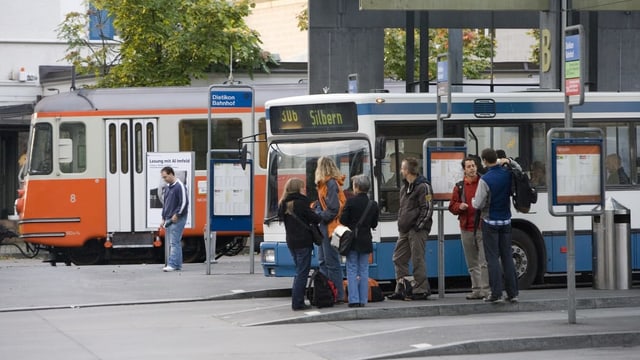Menschen warten an einem Bahnhof. Menschen warten an einem Bahnhof.