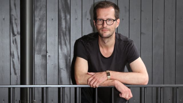 Tobias Brenk lehnt sich an ein Geländer. Tobias Brenk lehnt sich an ein Geländer.