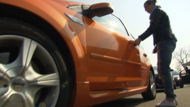 Eine junge Frau öffnet eine Autotür. Eine junge Frau öffnet eine Autotür.