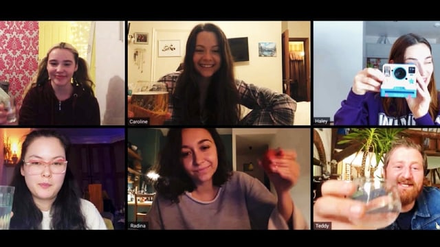 Fünf Frauen und ein Mann in einem Video Call. alle lächeln, zwei prosten sich zu, eine macht ein Foto mit einer Sofortbild-Kamera.