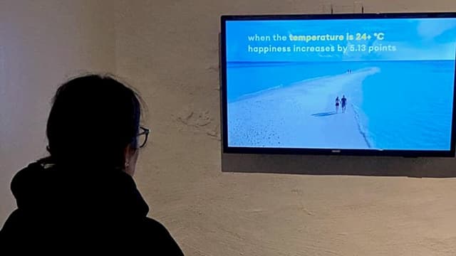Eine Frau starrt auf einen TV an der Wand. Eine Frau starrt auf einen TV an der Wand.