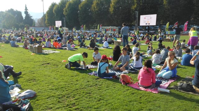 Die Schüler und Schülerinnen sitzen auf dem Sportplatz Die Schüler und Schülerinnen sitzen auf dem Sportplatz