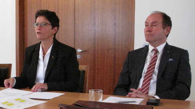 Zwei Männer und eine Frau an einem Tisch. Sie referiert. Zwei Männer und eine Frau an einem Tisch. Sie referiert.
